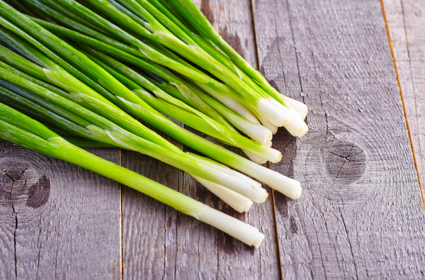Photo of green onions on a table. 